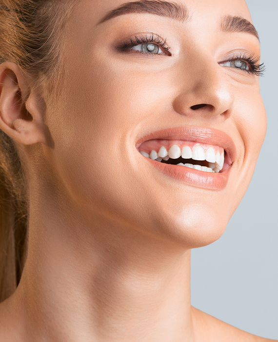 Smiling woman looking into mirror brushing her teeth smoothly